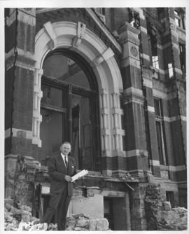 Mayor Stephen Juba standing in front of partially demolished City Hall building, April 27, 1962
