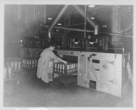Man loading machinery with shell cases at Dominion Bridge Company