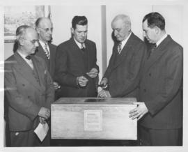 Mayor Garnet Coulter hammering shut a wooden box containing film and projector from Winnipeg phot...