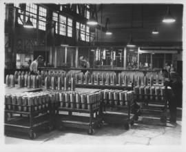 Shell cases on workbenches and carts at Dominion Bridge Company