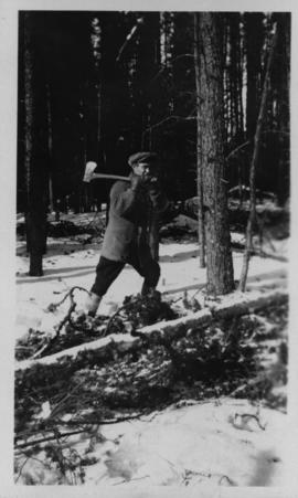 Man with ax at city wood camp, Greater Winnipeg Water District Railway