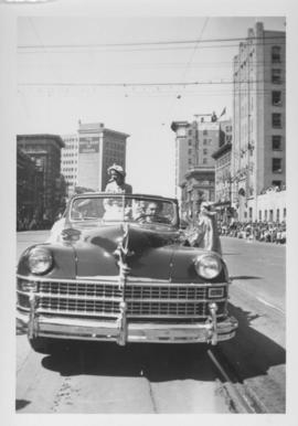 Woman riding in an automobile, Winnipeg's 75th Anniversary Parade