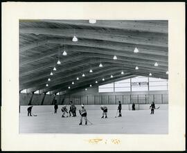 Children playing hockey in indoor rink