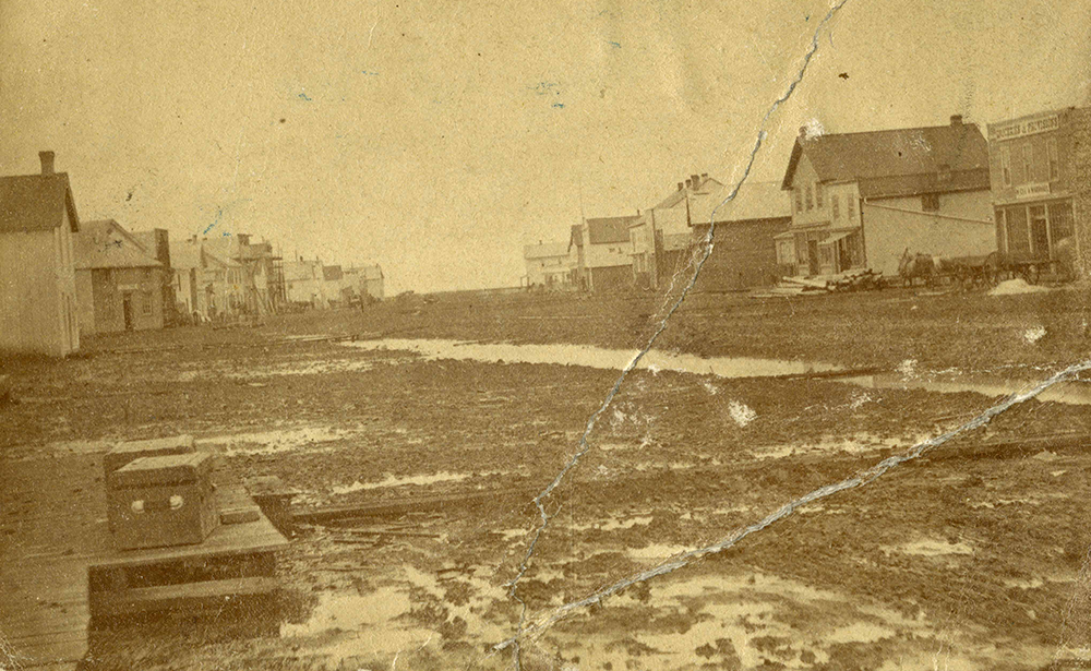 Muddy streets at the corner of Portage Avenue and Main Street in 1872, looking north. City of Winnipeg Archives Photograph Collection (P30 File 69).