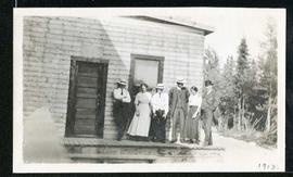 Men and women posing in front of building